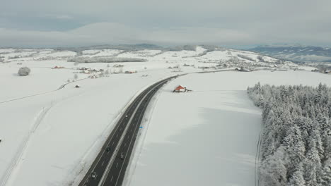 aerial of highway running through beautiful snow covered landscape