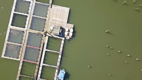 Aerial-Drone-view-over-boat-docks-bridge-and-small-town-on-a-hill