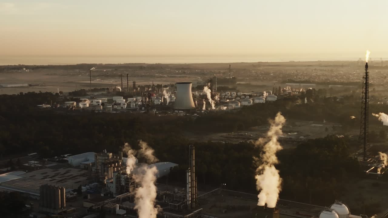 Aerial view of industrial oil and gas plant at sunrise, smoke in air