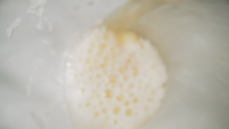 pouring fresh beer with froth into glass macro upper view