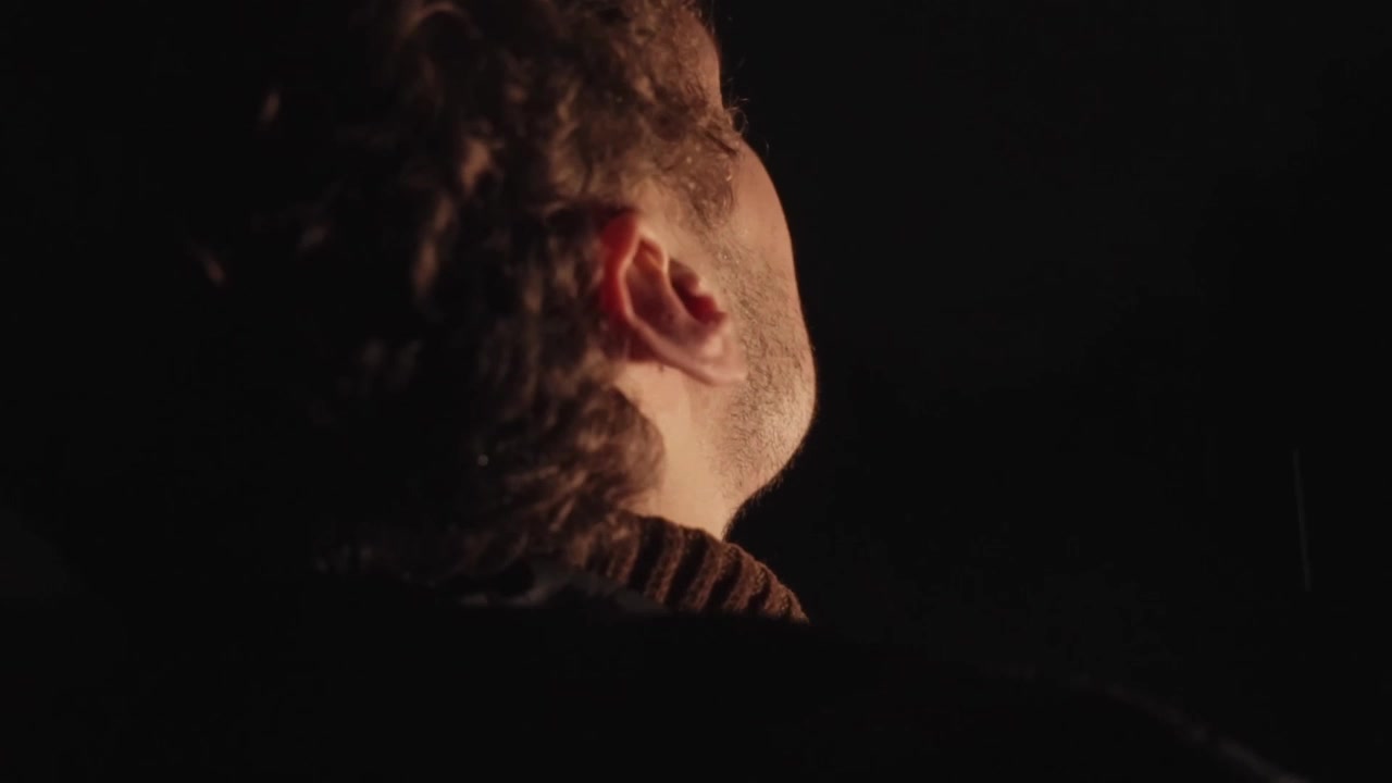 Ragazzo solitario in piedi sotto la pioggia di notte