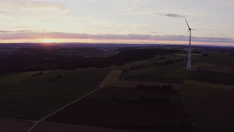 sunset over rural landscape with wind turbine