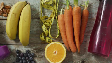 video of fresh fruit, measuring tape, water bottle and dumbbells on wooden boards