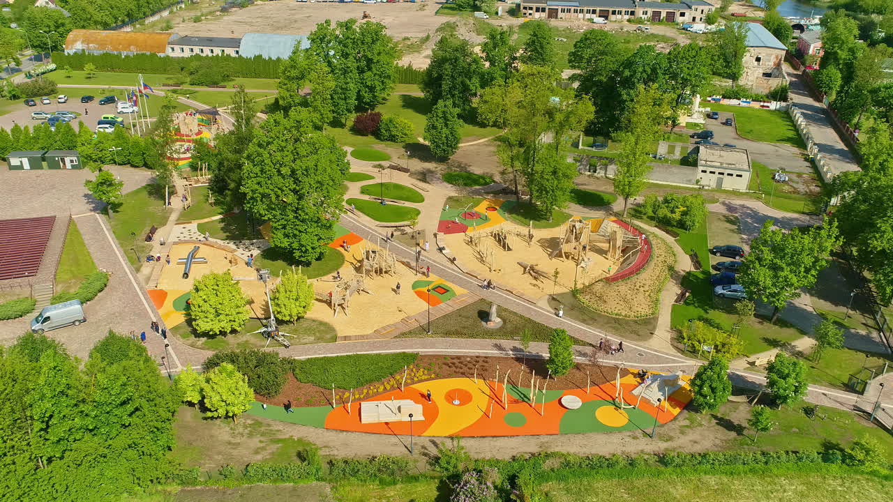 Aerial view circling a new playground and kids park on a sunny summer evening