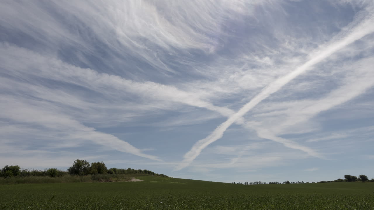 밝고 화창한 날에 녹색 들판 위의 하늘의 시간 경과