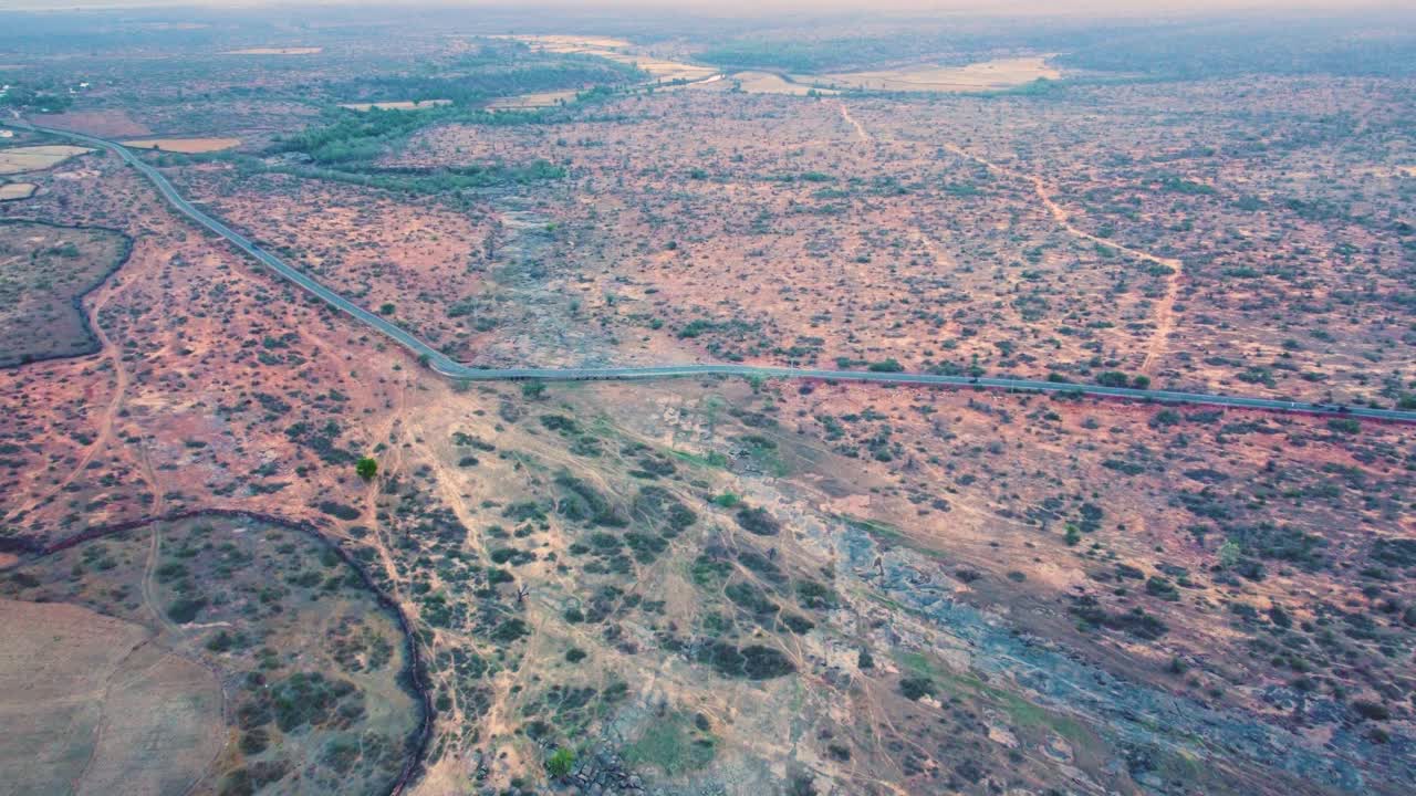 인도 마디아 프라데시 의 가우리오르 마을 도로 와 함께 말린 강 바닥 과 반 건조 한 숲 의 공중 드론  ⁇