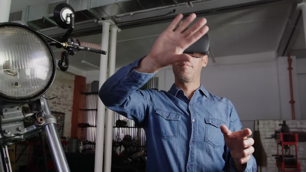 mecánico masculino usando auriculares de realidad virtual en un garaje de reparación de motocicletas 4k