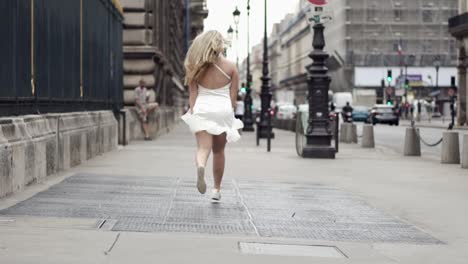 woman in white dress running through paris