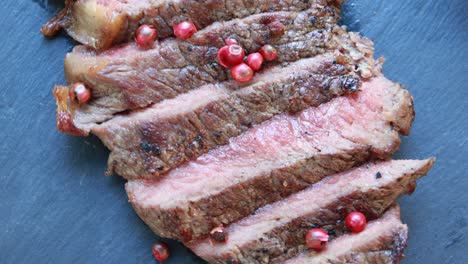 top view of ribeyes pink peppercorn steak, beef sliced ripe medium rare level.