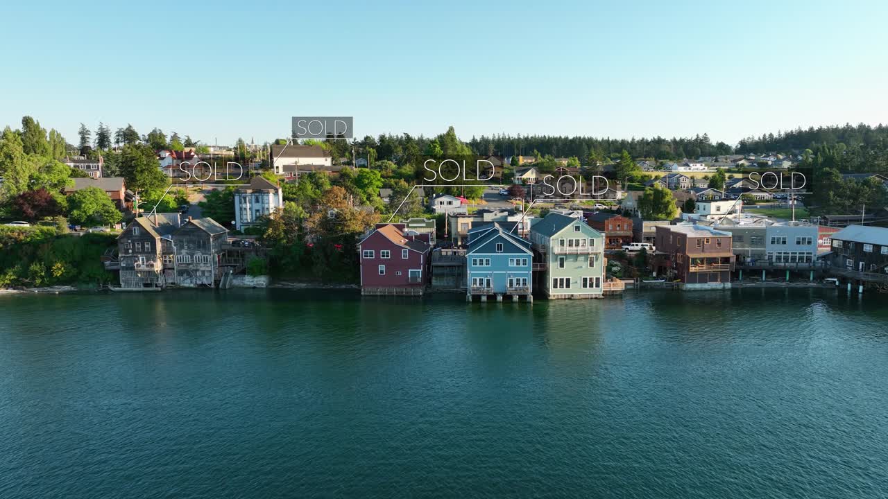 Aerial view of seaside houses with &amp;quot;SOLD&amp;quot; signs floating above the structures