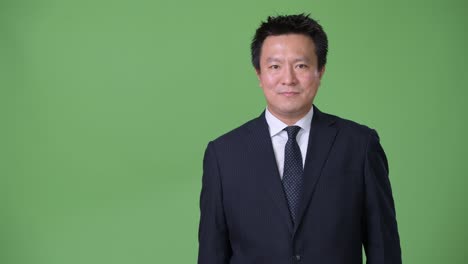 녹색 배경에 성숙한 일본 사업가