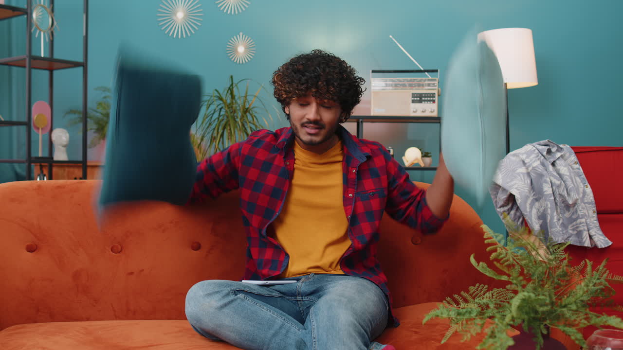 Repair work at neighbours concept irritated man at home cover ears with pillows annoyed by noise