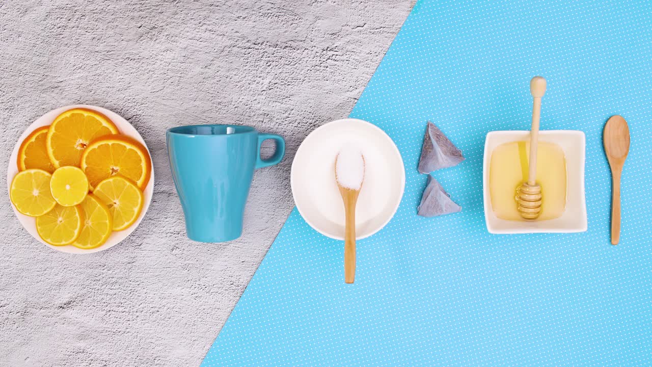 taza azul, limones en rodajas miel y azúcar aparecen y desaparecen de arriba y abajo. detener el movimiento