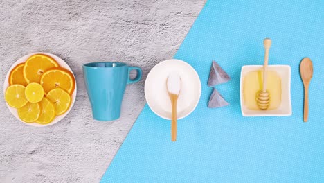 taza azul, limones en rodajas miel y azúcar aparecen y desaparecen de arriba y abajo. detener el movimiento