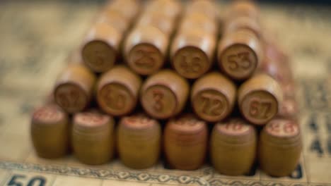 cinematic creative close-up smooth forward macro shot of bingo wooden barrels in a row, woody figures, old numbers background, vintage board game, slow motion 120 fps commercial gimbal video