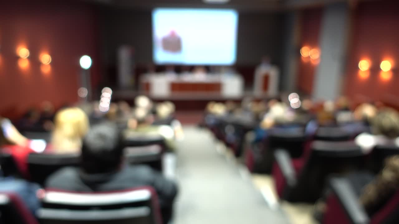 Pubblico sfocato che partecipa a una conferenza o presentazione in un auditorium