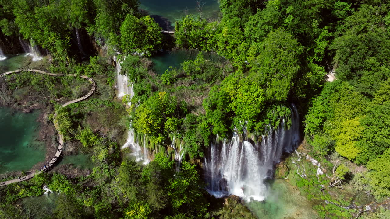 Lush Green Forest With Cascading Waterfalls At Upper Lakes Of Plitvice Lakes National Park In Croatia. aerial orbiting shot