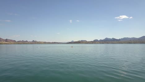 kayakers in lake with mountains 4k