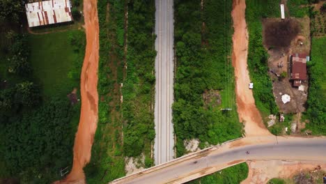 top down aerial of a long traintrack running through a rustic area in nigeria, africa on a sunny day