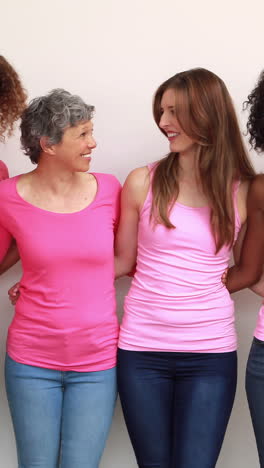 mujeres felices con camisas rosadas de pie