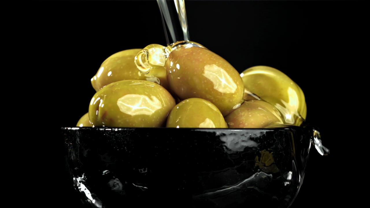 Olio d'oliva che cola su olive verdi in una ciotola nera