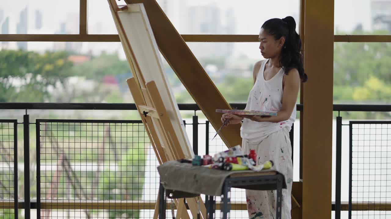 Artista donna che dipinge su un cavalletto