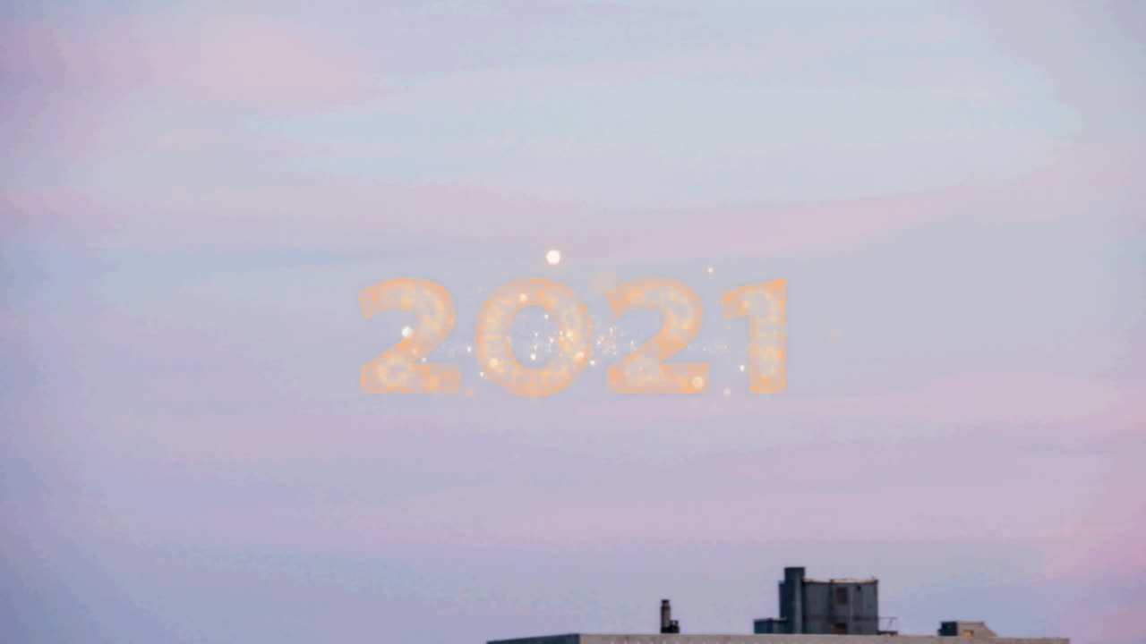 texto de 2021 sobre fuegos artificiales que estallan contra una vista aérea del paisaje urbano
