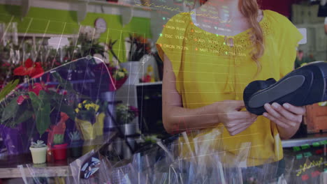 la florista está usando una terminal de tarjeta de crédito en la floristería.