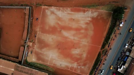 aerial view above people soccer in middle of a african city - top down, drone shot