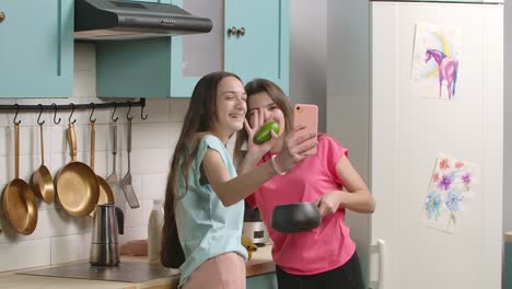two girls cooking together and taking a selfie