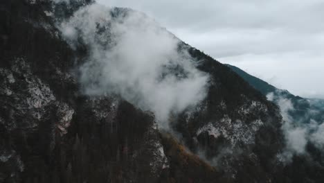 atmospheric and moody drone footage of mountainous landscapes in austria with wet and misty conditions