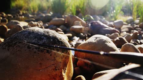 fly fishing rod, reel and hook on rock