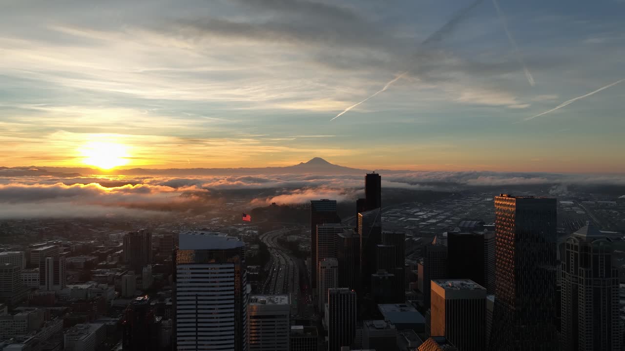 Vista aérea da paisagem urbana de Seattle pela manhã com um nascer do sol dourado e nuvens baixas.