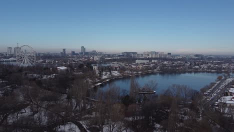 Aerial-Of-Ferris-Wheel,-Park-And-A-Lake-At-Winter