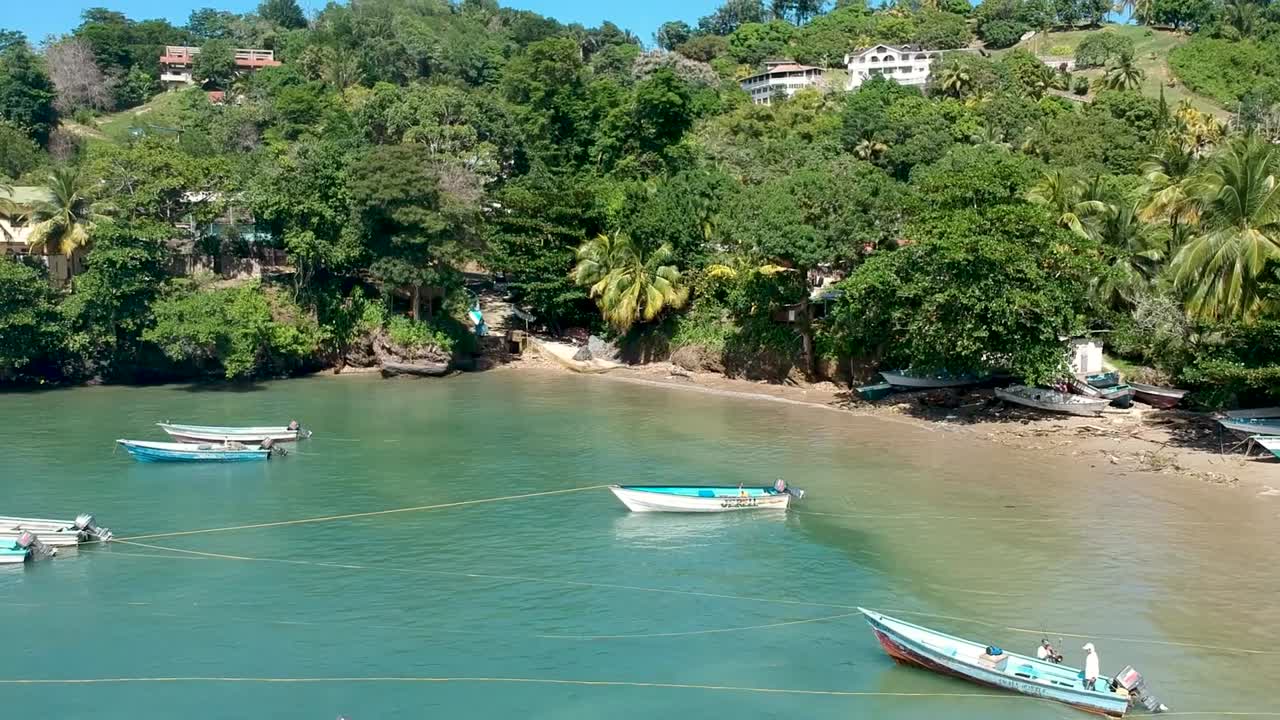 toma de drones de la playa de las cuevas en el norte de trinidad con playa, botes y montañas