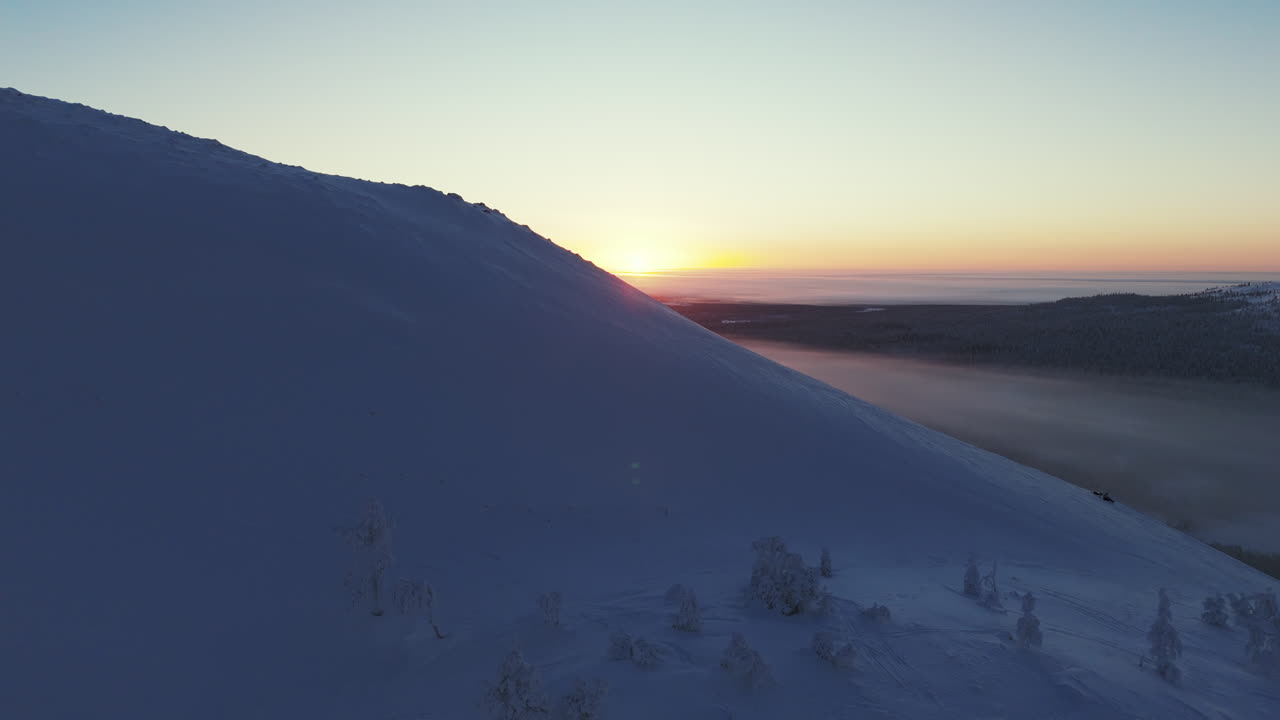 un maravilloso valle de invierno se revela detrás de la montaña
