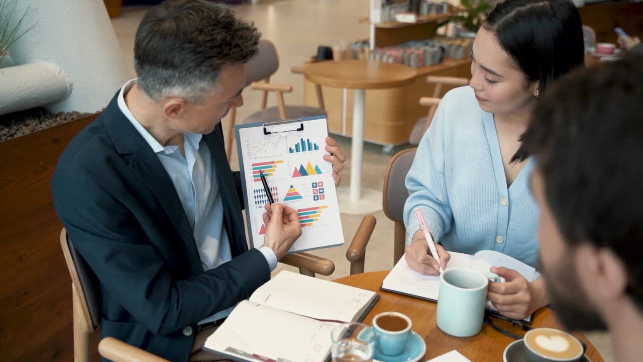 un equipo de trabajo analizando y comparando detalles de algunos datos en un informe