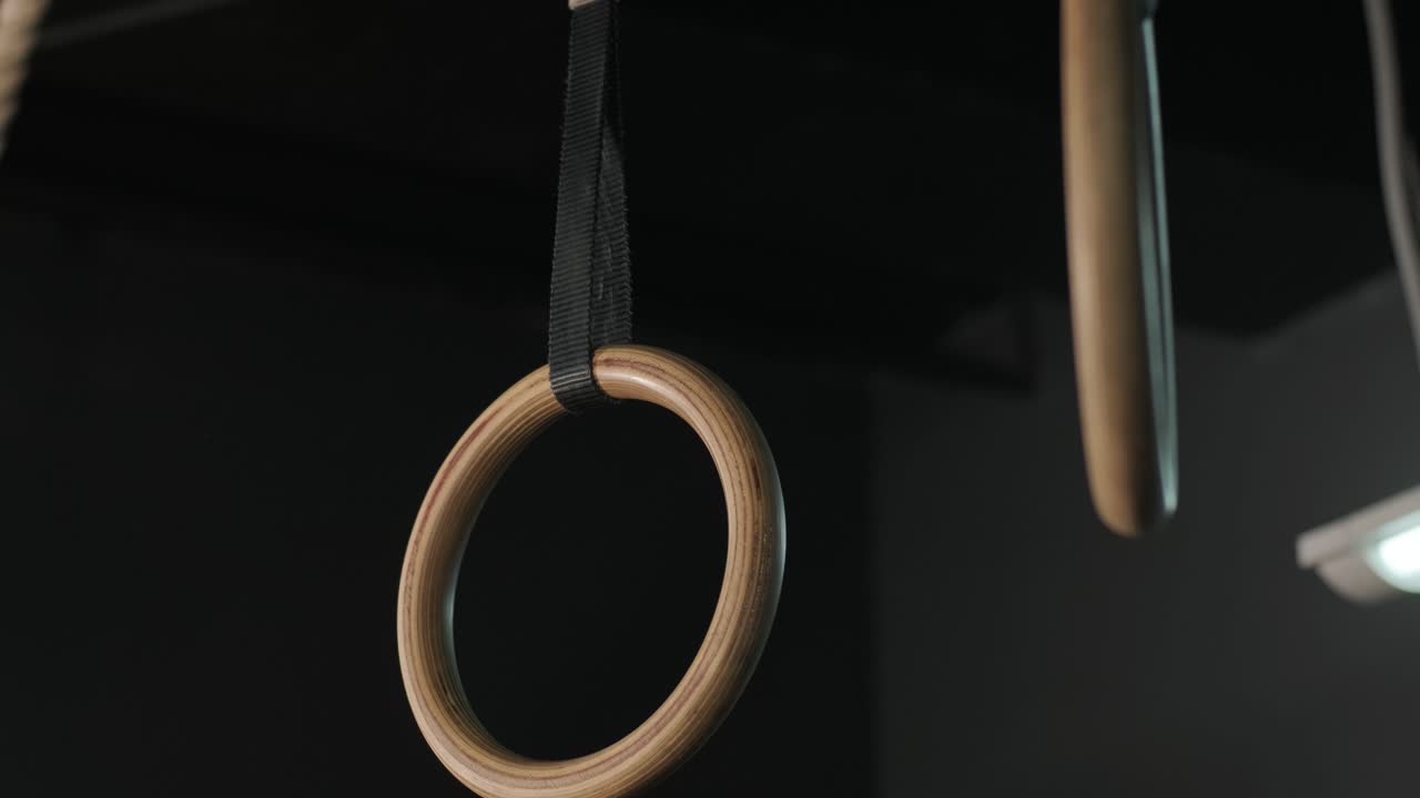 운동 선수는 체조 링을 사용하여 운동을 훈련하고 있습니다. 체육관에서 보디빌딩 연습, 손 가까이