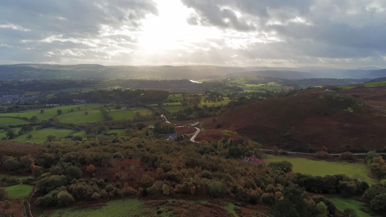 rayos de sol moviéndose a través de mosaicos rurales campo pradera paisaje de tierras de cultivo vista aérea hacia adelante