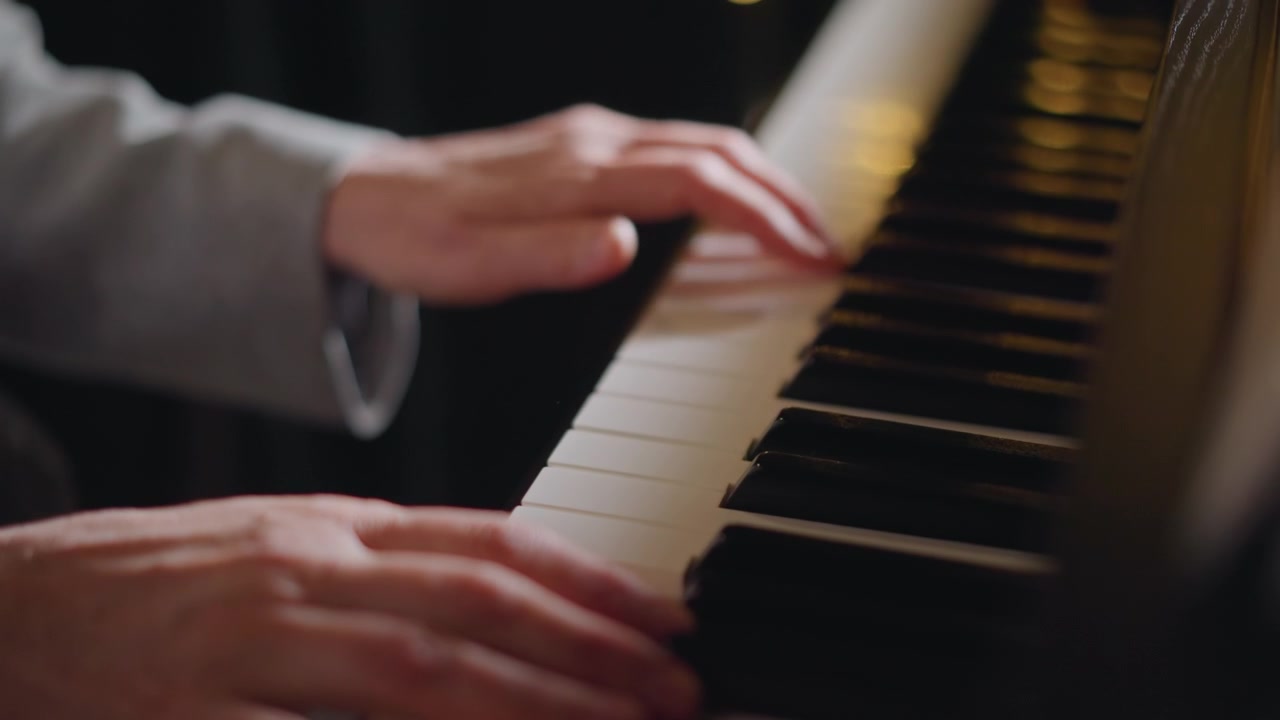 Closeup hands on piano keys playing arpeggios, seasoned instructor guides delicate phrasing in warm studio with soft bokeh lighting, attentive posture and detailed finger technique during classical