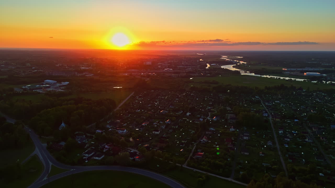 Glowing bright sunset above urban area, aerial drone view
