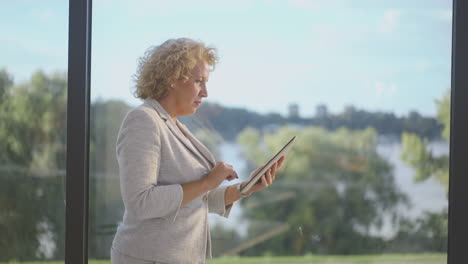 business woman using tablet by window