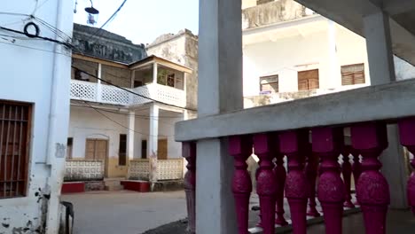 renovated pink terrace between some deteriorated buildings in old town street