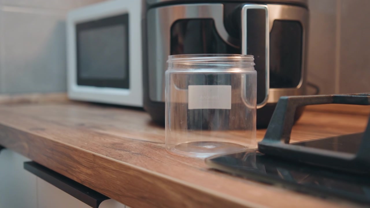 Barattoli e utensili disposti in una cucina luminosa. Forniture per la cottura organizzate su un bancone di legno per una sessione di cucina. Angolo cucina pulito e ordinato con barattoli e utensili pronti per le attività di cottura.