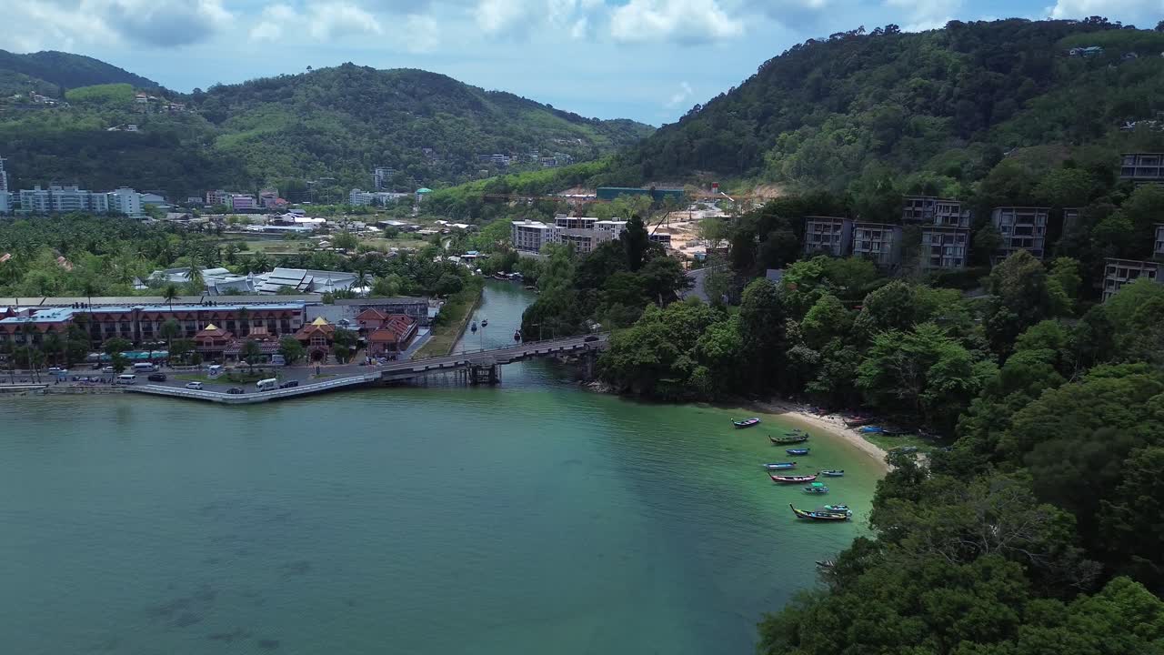 Quang cảnh trên không của những ngọn đồi nhiệt đới tươi tốt được bao phủ bởi rừng rậm dẫn đến bờ biển yên bình tạo nên một cảnh quan thiên nhiên tuyệt đẹp ở Patong Phuket, Thái Lan, Đông Nam Á.