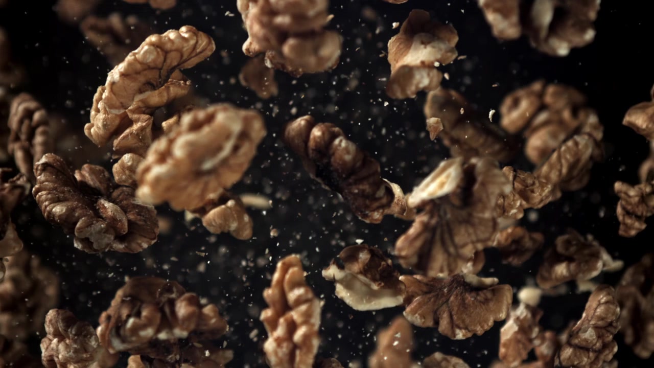 Walnut Halves Falling in Super Slow Motion on Black Background