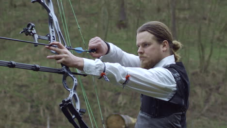 business man in suit aiming for goal with bow, closeup slow motion, side view