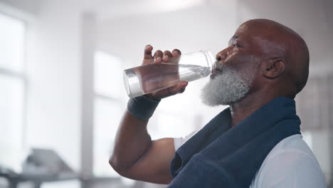 senior man drinking water after workout