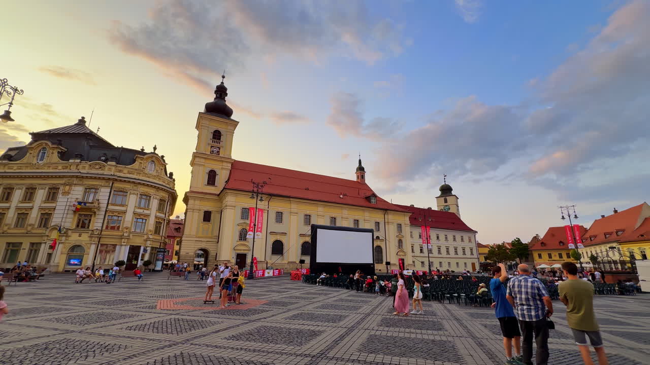 Sibiu, Romania, 1 July 2025: Historic church and square in Sibiu. Old church and surrounding historic buildings in Sibiu Romania with people walking in the square