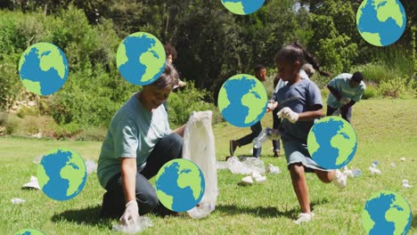 animation of falling globes over happy diverse group picking up rubbish in countryside